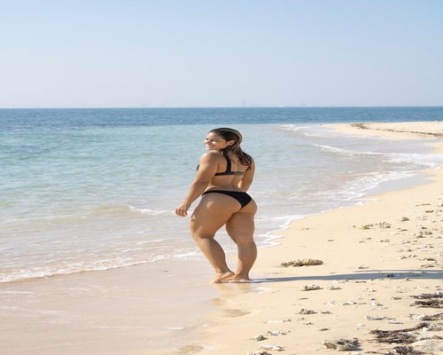 Mujer realizando estiramientos suaves por la mañana en su departamento
